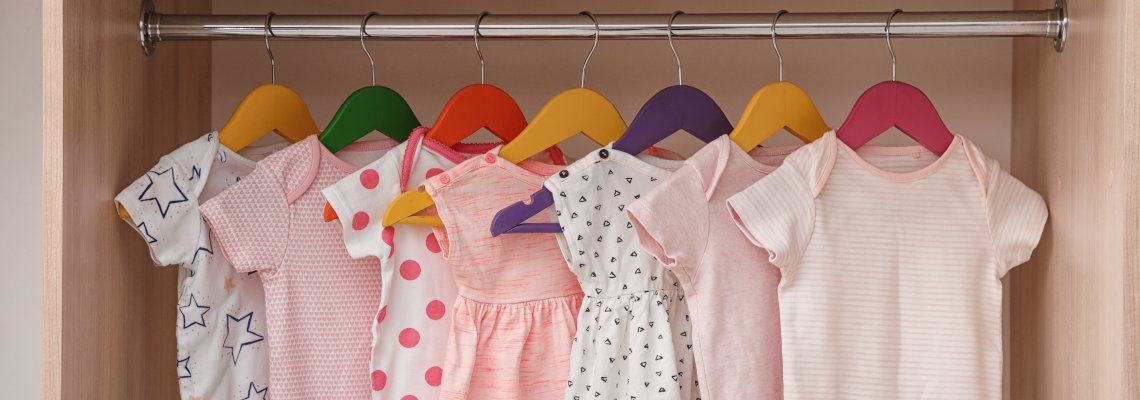 Babykleidung- und Ausstattung auf Rosa-Hintergrund